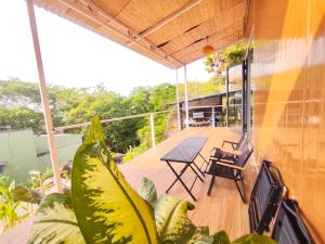 a balcony of a house with a table and a plant at La An Homestay in Vĩnh Hy