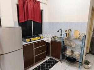 a kitchen with a sink and a refrigerator at MonoStay Samarahan in Kota Samarahan