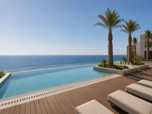 a swimming pool with a view of the ocean at Raffles Jeddah in Jeddah