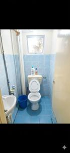 a blue tiled bathroom with a toilet and a sink at MonoStay Samarahan in Kota Samarahan