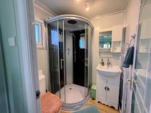 a bathroom with a shower and a sink at AAK cabin - standalone riverfront cabin in Malanda