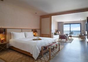 a bedroom with a large bed and a living room at Unico Hotel Riviera Nayarit - Adults Only - All Inclusive in Nuevo Vallarta