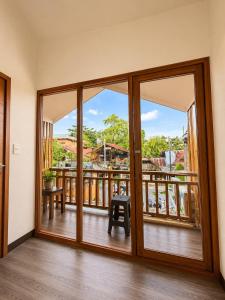 a room with a balcony with sliding glass doors at Bayay Isla Inn in General Luna