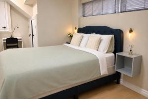 a bedroom with a large bed with a blue headboard at Vita House - Minutes to Rogers Stadium - Walk or Transit - Near VELD Downsview and Yorkdale in Toronto +28 photos