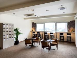 a restaurant with tables and chairs and a bar at Hotel Route-Inn Mojiko in Kitakyushu +29 photos