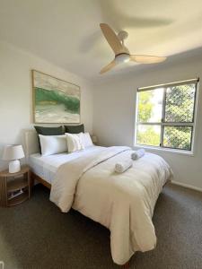 a bedroom with a large bed and two windows at Iluka in Yeppoon +23 photos