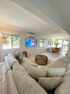 a living room with a couch and a tv at Iluka in Yeppoon