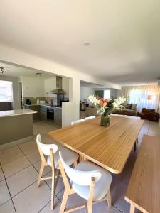 a kitchen and dining room with a wooden table and chairs at Iluka in Yeppoon