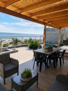 a patio with a table and chairs and the beach at La Casa de David in Zorritos