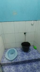 a bathroom with a blue toilet and a bucket at NN Kost 009 Manage by Omm Kost in Beran-kidul