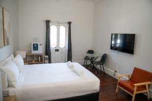 a bedroom with a large white bed and a chair at Rec Toodyay Hotel in Toodyay