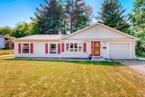 a white house with a red door and a yard at Sherry Road Retreat in South Burlington