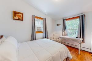 a white bedroom with a bed and a window at Sherry Road Retreat in South Burlington