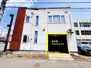 a building with a parking lot sign in front of it at STAY3‐11 in Asahikawa