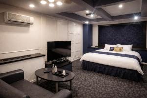 a hotel room with a bed and a flat screen tv at Hotel Piatt Nagoya in Nagoya