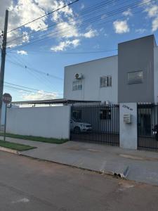 a white building with a gate in front of it at Apartamento completo in Nova Mutum