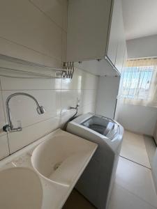 a bathroom with a sink and a washing machine at Apartamento completo in Nova Mutum +10 photos