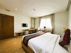 a hotel room with a bed and a television at Zesty Hostel & Bistro in Nha Trang