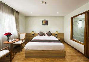 a hotel room with a bed and a table and a window at Zesty Hostel & Bistro in Nha Trang