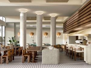 a restaurant with columns and wooden tables and chairs at Novotel St Kilda in Melbourne