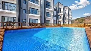 a large blue swimming pool in front of a building at Stonecove Pension in Geoje