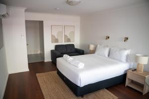 a bedroom with a large white bed and a couch at Rec Toodyay Hotel in Toodyay