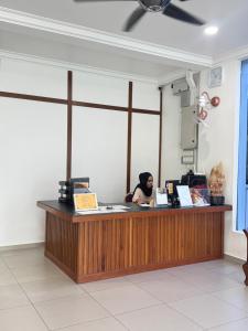 a woman sitting at a counter in a room at LSH Perlis Rest House in Kangar