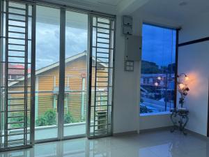a room with large windows with a view of a building at LSH Perlis Rest House in Kangar