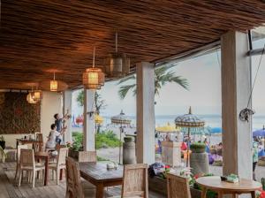 a restaurant with a view of a beach with tables and chairs at Tepi Segara Seminyak in Seminyak