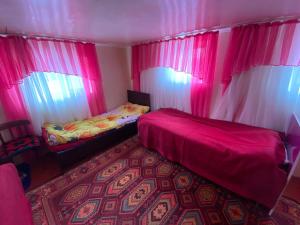 a room with two beds and pink curtains at ILGIZ HOUSE Barskoon in Barskoon