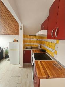 a kitchen with red cabinets and a white refrigerator at Apartmani Banić Apartman 5 in Postira