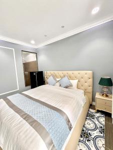 a bedroom with a large bed with white sheets and blue pillows at Khách Sạn PG Boutique in Vung Tau