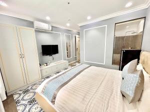 a bedroom with a large bed and a television at Khách Sạn PG Boutique in Vung Tau