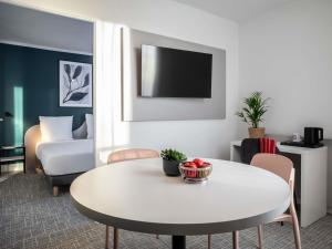 a living room with a white table and a couch at Adagio Access Paris Nanterre in Nanterre +45 photos