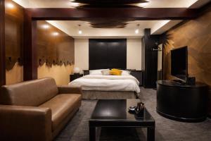 a hotel room with a bed and a couch at Hotel Piatt Nagoya in Nagoya