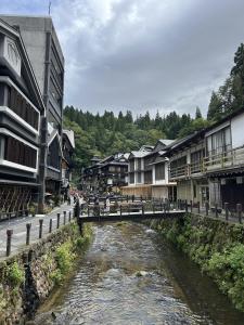 a bridge over a river in a town with buildings at Tomaru細野 in Nobezawa