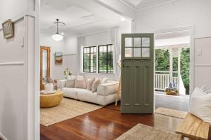 a living room with a green door and a couch at Treehaven House & Cottage - Maleny Retreat in Maleny