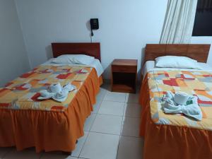 two beds sitting next to each other in a room at Hotel Pradera de los Celajes in Cajamarca