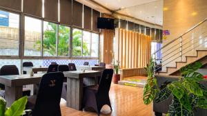 a dining room with tables and chairs and windows at Vio Hotel Pasteur in Bandung +60 photos