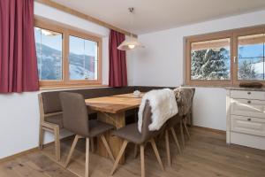 a dining room with a wooden table and chairs at Ferienwohnungen H&P in Alpbach