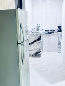 a kitchen with a refrigerator and a white tile floor at Posada Francelly in San Andrés