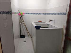 a white bathroom with a sink and a broom at Felipe's House in Ibagué
