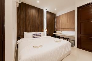 a bedroom with a white bed with two slippers on it at Continuum Hotel Udonthani in Udon Thani