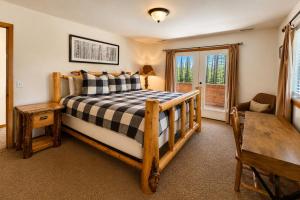 a bedroom with a bed and a table and a chair at Just Plain Getaway in Leavenworth