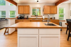 a kitchen with white cabinets and a wooden counter top at Just Plain Getaway in Leavenworth +61 photos