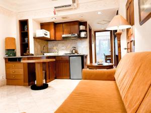 a kitchen with wooden cabinets and a table at Club Bali Suite Legian in Legian