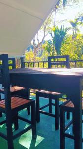two benches and a table and chairs on a patio at Ella Kumi Wood Cabin in Ella