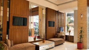 a living room with a couch and a tv at Vio Cihampelas in Bandung