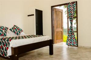 a bedroom with a bed and a sliding glass door at Riverwalk cabañas junto al rio in Calarcá