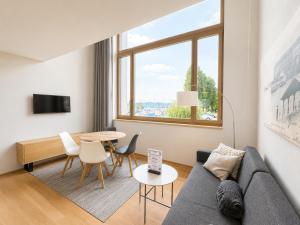 a living room with a couch and a table at LAKE-LOFT APARTMENT's direkt im Hafen in Romanshorn